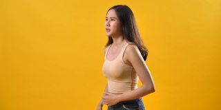 妇女胃痛痛分离在黄色背景上