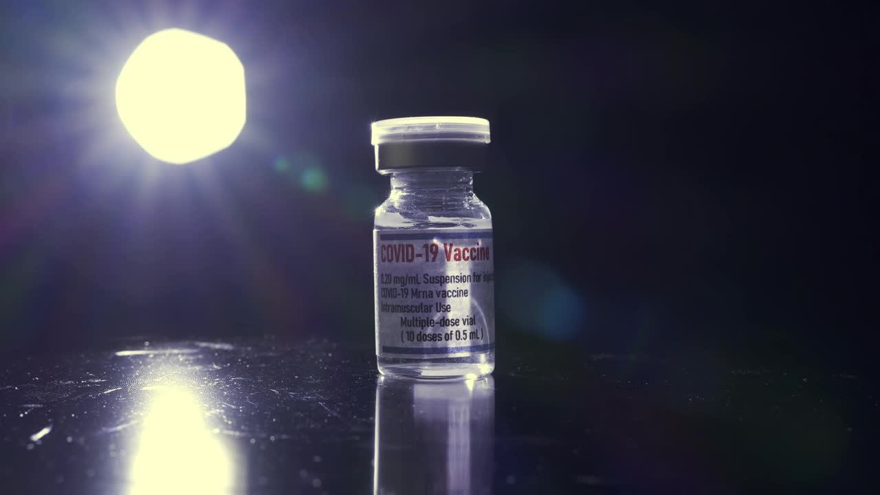 黑色背景下Covid-19疫苗瓶的特写