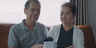 亚洲老年夫妇在家中测量血压。
