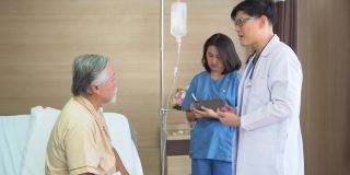 亚洲医生检查老年老人病人与护士妇女使用数码平板电脑与老人病人在医院床上交谈
