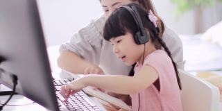 亚洲母亲和女儿练习在家学习