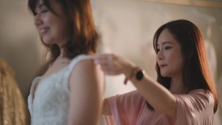 亚洲华人女婚纱店老板正在为顾客测量新娘的体型，为顾客量身定制婚纱视频素材模板下载