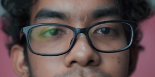 近距离拍摄中不完美的亚洲男人的眼睛戴眼镜