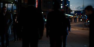 一群用科技跟踪的商人在繁忙的夜晚城市街道上行走。CCTV AI人脸识别大数据分析界面扫描，显示动画信息。