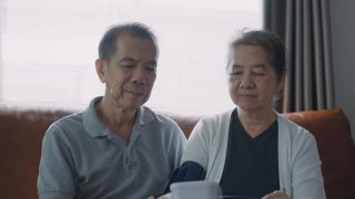 亚洲老年夫妇在家中测量血压。视频素材模板下载