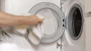 男人们的手把白色的衣物放进洗衣机。准备要洗的衣服，侧视图视频素材模板下载