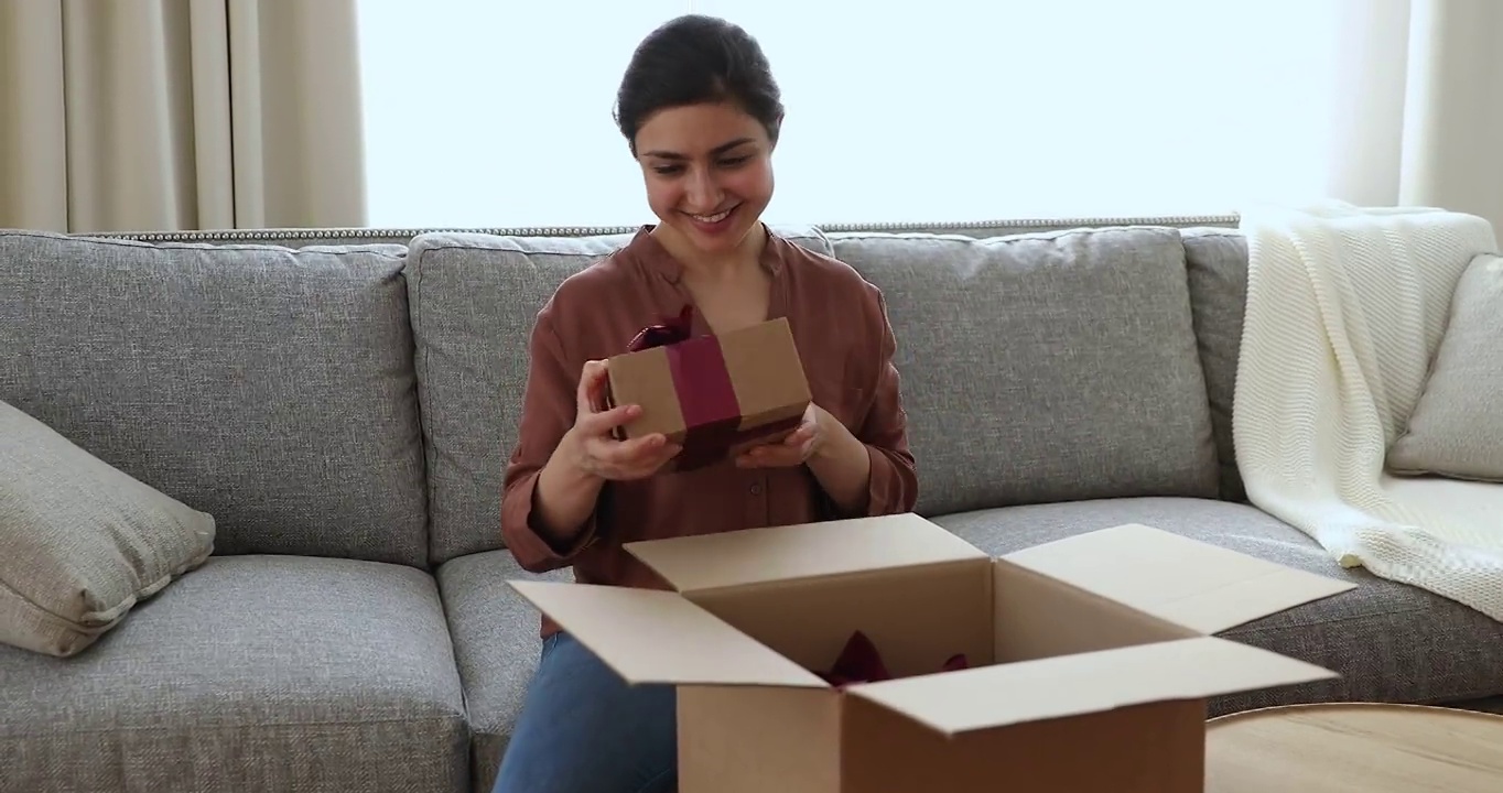 快乐的印度女人打开了装满礼物的包裹盒