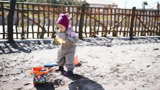 小女孩在操场上玩沙子、铲子和水桶视频素材模板下载