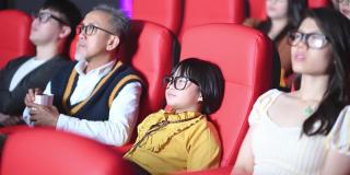 一群中国观众带着3D眼镜在电影院观看3D电影