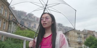 年轻的亚洲女人高兴雨停了，合上伞去散步