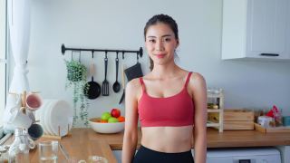 亚洲活跃女人的肖像在运动服看相机在屋里。美丽的运动女孩喜欢吃干净的沙拉，在家里和交叉双臂的健康运动后。饮食和健康食品的概念。视频素材模板下载