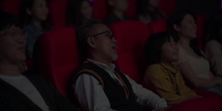 一位亚裔中国老人和他的孙女在电影院看电影睡着了