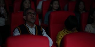 一位亚裔中国老人和他的孙女在电影院看电影时睡着了