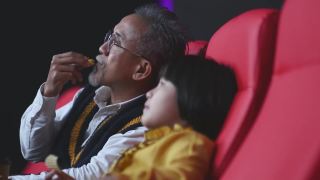 亚洲华人活跃的老人和他的孙女喜欢在电影院看电影视频素材模板下载