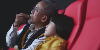 亚洲华人活跃的老人和他的孙女喜欢在电影院看电影