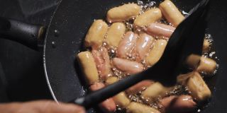 把香肠放在满锅滚烫的油里煎。捡起。脆皮和垃圾食品菜单。泰国的美味菜单。前视图。