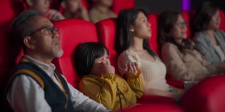 亚洲华人活跃的老人和他的孙女在电影院看伤感感人的电影
