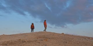游客在冰岛的地热田漫步，天空湛蓝