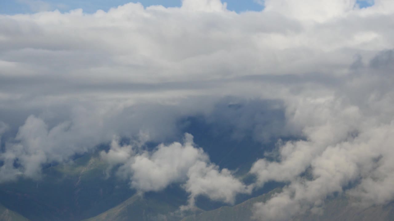 4千片蓬松的云团翻滚在西藏的山顶和山谷，世界之巅。