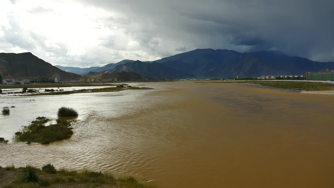 四千条拉萨河，远处黑云团翻滚在西藏山顶。
