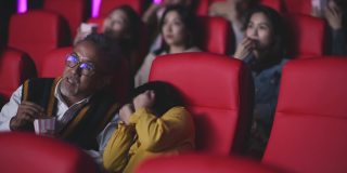 亚洲华人活跃的老人和他的孙女在电影院看恐怖惊悚电影