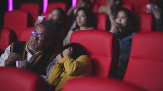 亚洲华人活跃的老人和他的孙女在电影院看恐怖惊悚电影视频素材模板下载