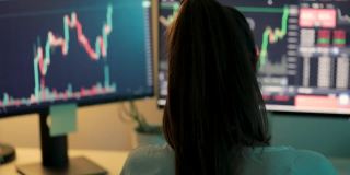 女人在电脑显示器上看股票行情图