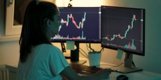 年轻女子使用台式电脑跟踪和交易加密货币