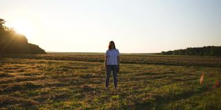 画面中的女性，镜头靠近，背景中的田野，日落