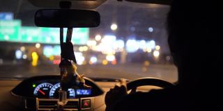 一个亚洲人在夜里握着方向盘开车