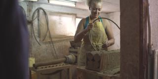 女陶工使用弓竖琴切割机将生陶土切割在碎片上