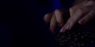 一名年轻女子给社交网络写信。电脑黑客输入代码病毒电脑键盘深夜工作。记者在媒体上写文章。在笔记本电脑上工作，在键盘上打字，现代商务