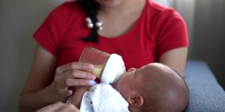 亚洲妇女在家里给婴儿喂奶