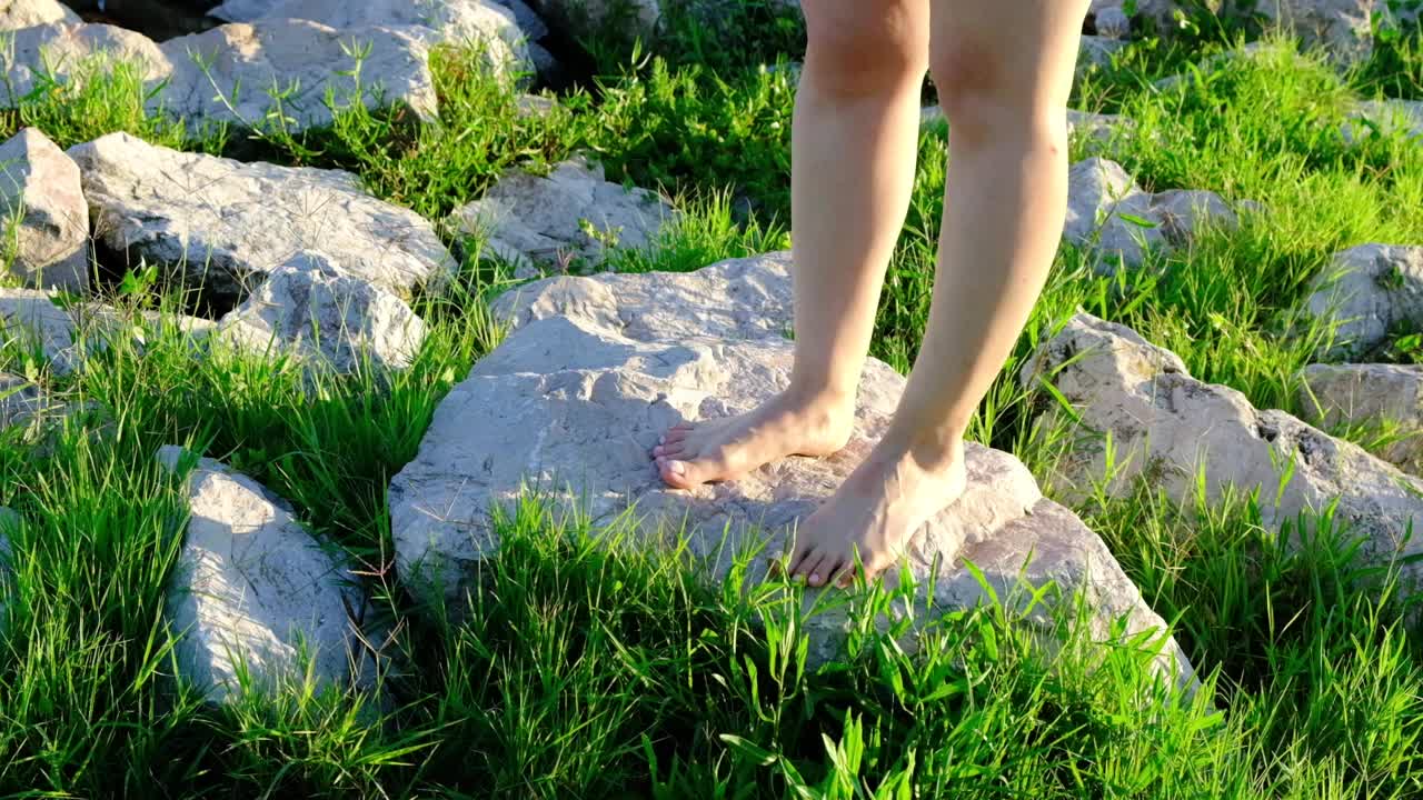 赤脚在岩石上行走的女人。
