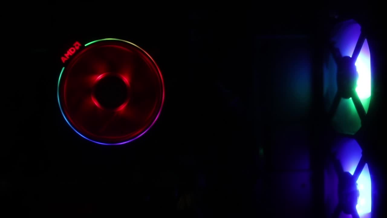 RGB PC旋转的冷却风扇与明亮的旋转上的黑色背景和多色RGB光与安全网。