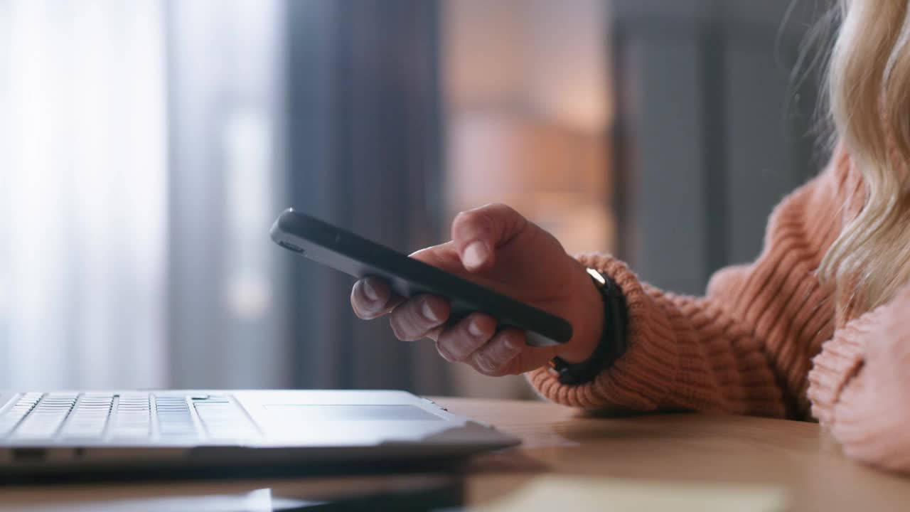 一名女性在家工作时使用智能手机的4k视频片段