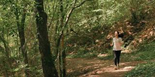 越野跑步。一个穿着运动服的心不在焉的女人在森林里慢跑。缓慢的运动。有氧运动训练和健康生活方式的概念