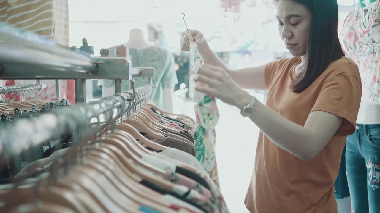 亚洲女人在购物中心挑选衣服