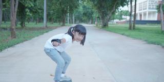 亚洲女孩在路上玩滑板，冲浪滑板