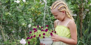 一个扎着马尾辫的年轻女孩在她家后院的花园里照料鲜花。热爱种植和照顾植物。