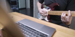 50Fps，一个摇滚音乐家通过互联网上的在线免费和弦练习他的电子吉他技能，使用数字笔记本电脑，社交媒体在线娱乐姿势，直播，硬技能提高