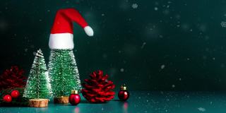 圣诞快乐，新年快乐的雪花飘落与圣诞树和红色的圣诞老人帽子在深绿色的背景。节日庆祝贺卡
