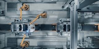 空中汽车工厂3D概念:自动化机器人手臂装配线制造高科技绿色能源电动汽车。建筑，焊接工业生产输送机。Top View Time-Lapse Loop