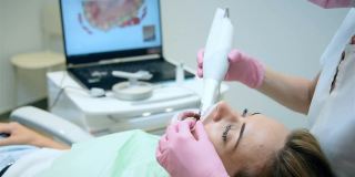 牙科医生用口腔内扫描仪扫描病人的牙齿。