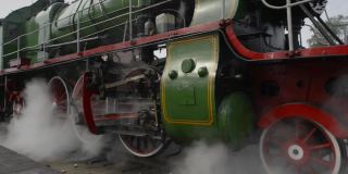 老式蒸汽机的车轮、烟雾、蒸汽和声音。