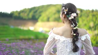 美丽的新娘手捧一束鲜花在山上的花园里视频素材模板下载