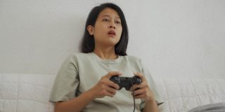 亚洲年轻女子玩电子游戏手柄