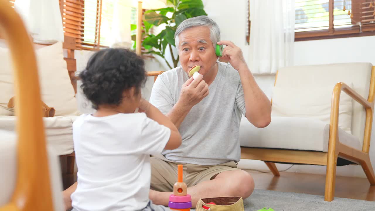 爷爷和小孙女在家里客厅里玩得很开心