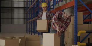 一组工人正在仓库内积极包装纸箱进行物流配送。建筑工人信心十足地团队工作，完成装箱工作。运输业务。概念蓝领
