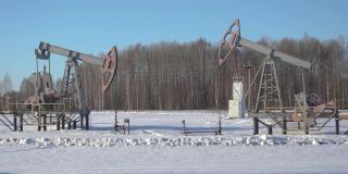 两个油泵在田野里，冬天雪花飘飘